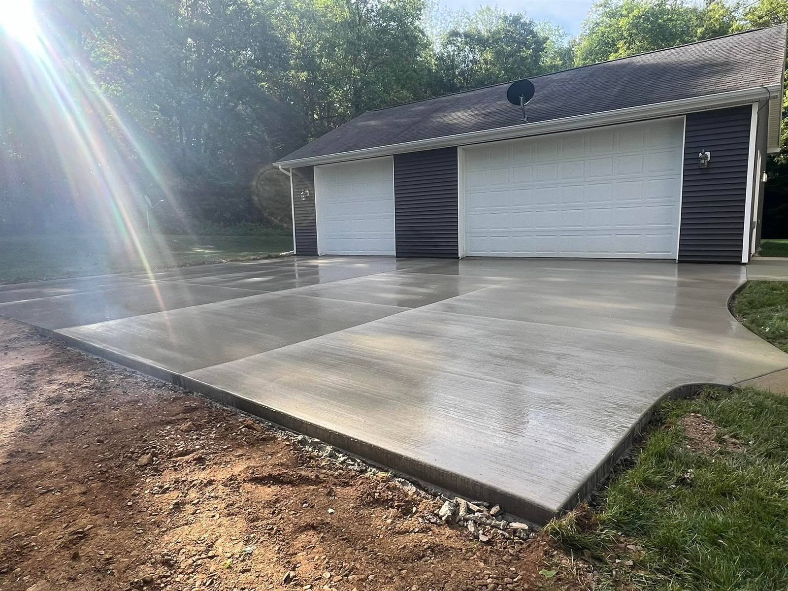 Smooth finished concrete apron in front of a three-stall garage
