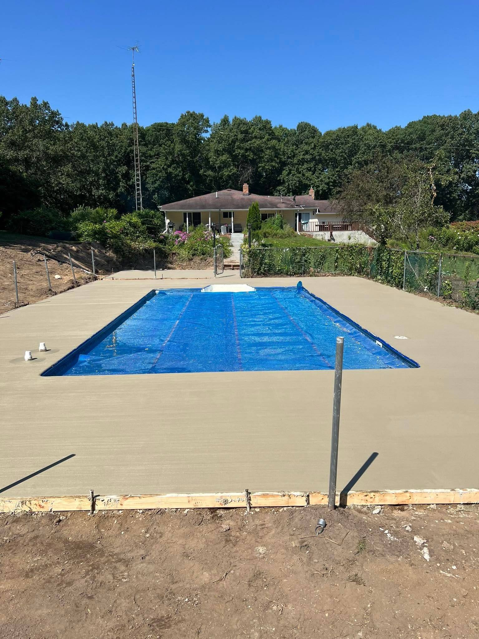 New concrete pool deck poured around an in-ground pool